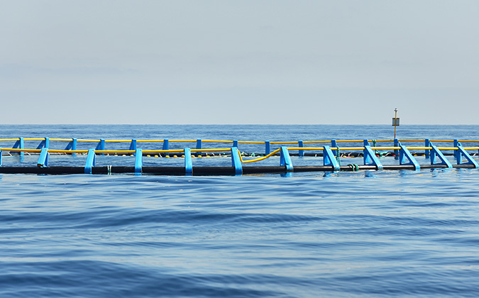 Fish farm in an open Mediterranean sea, close-up, Spain. Food industry, traditional craft and alternative production, environmental damage and conservation